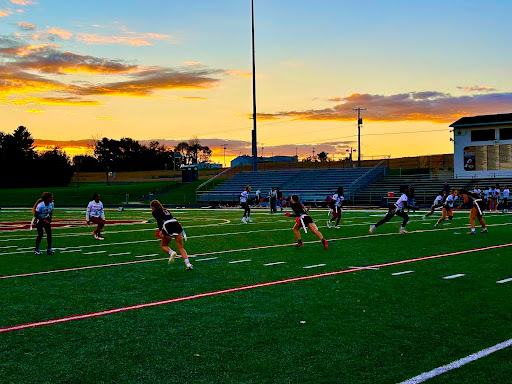 The sun sets on the flag football game.