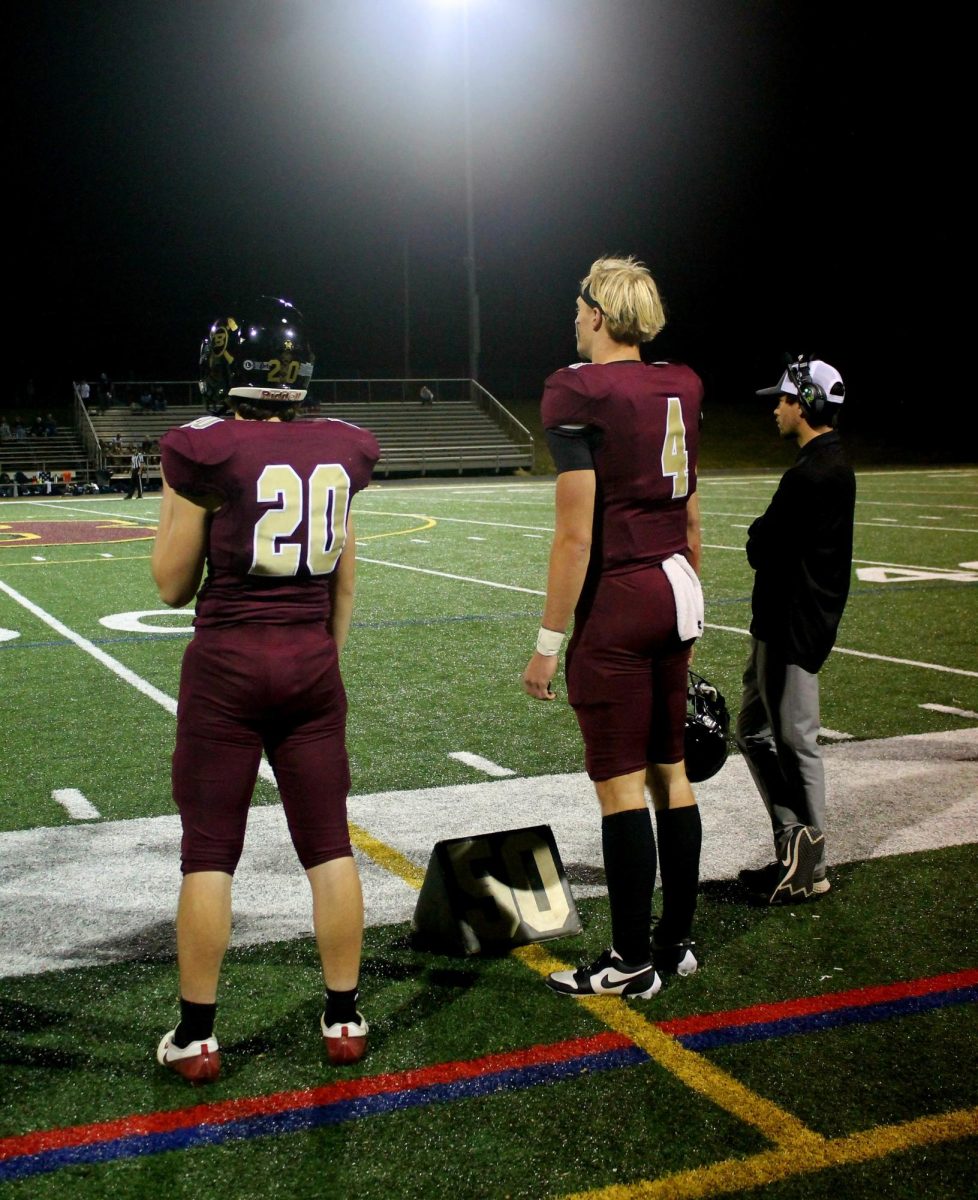 Ethan Houck and Nate Houck watch from the sidelines.