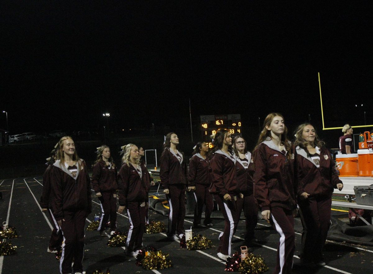 The cheerleaders continue to watch the game.