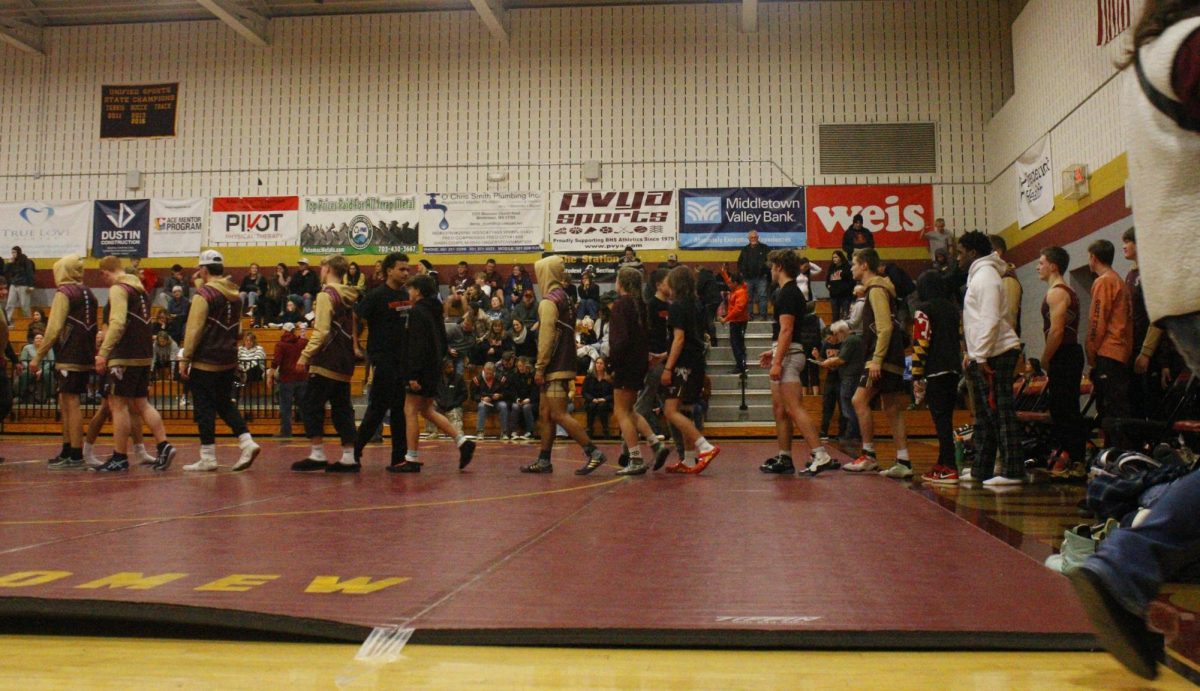 The wrestling team walks into the gym.