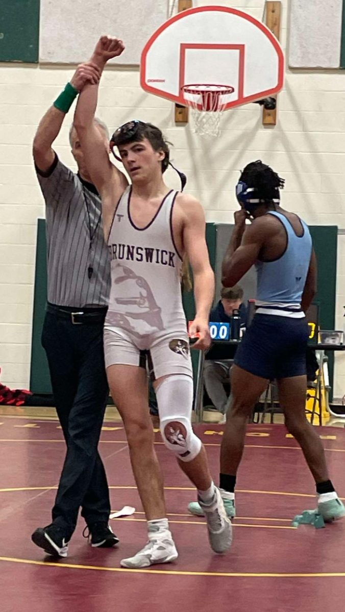 Colby Moore, a junior, wins his match after a tiring competition.