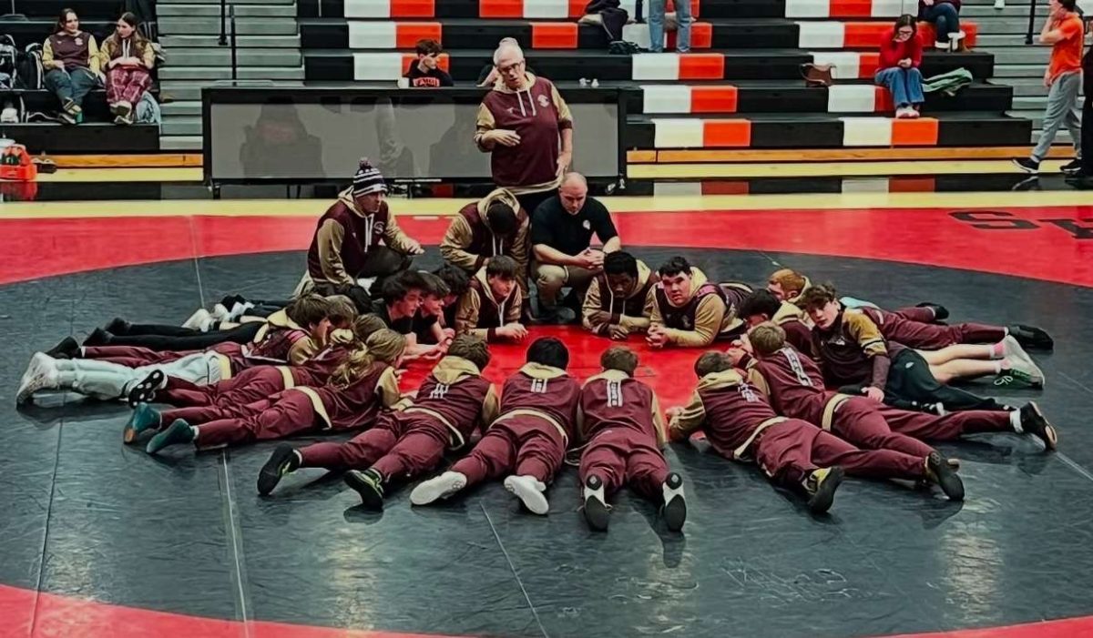 2025 Brunswick Wrestling team meets around the mat.