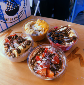 Four Playa Bowls full of added fruit, chocolate, and granola options at the storefront.