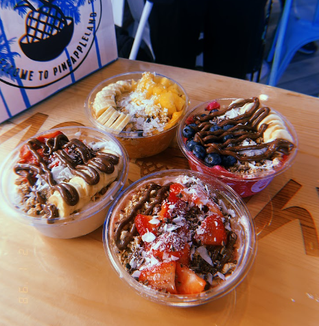 Four Playa Bowls full of added fruit, chocolate, and granola options at the storefront.