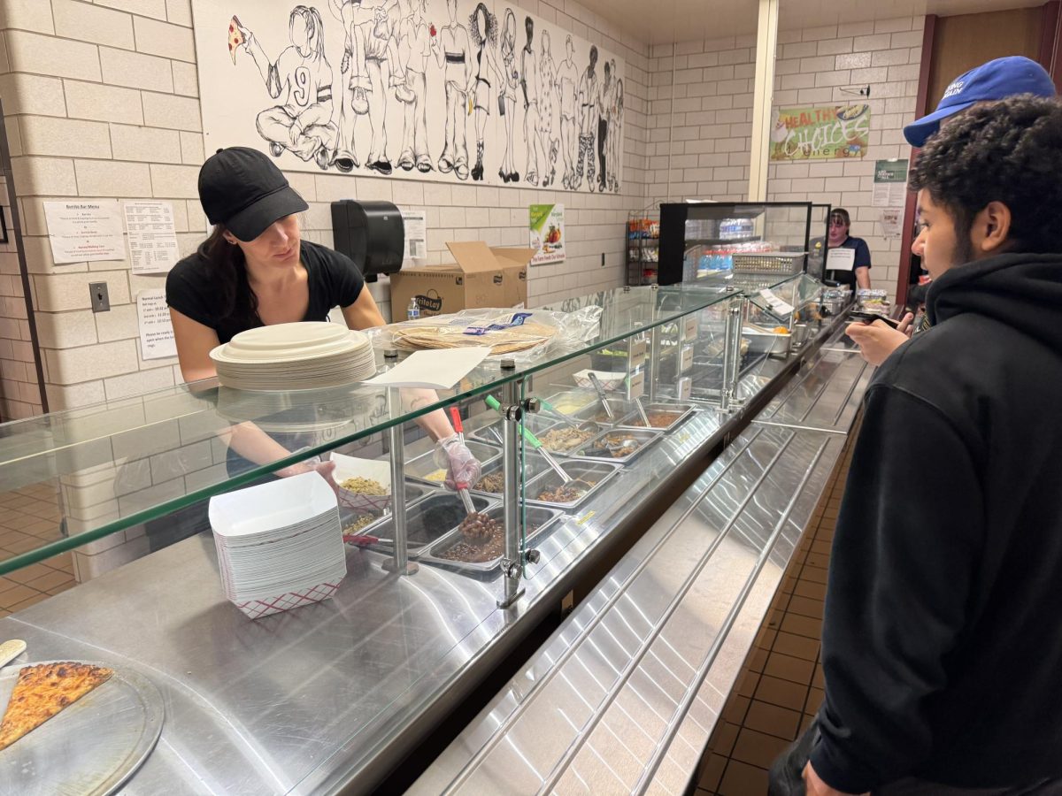 A school lunch lady prepares lunches for Brunswick students.