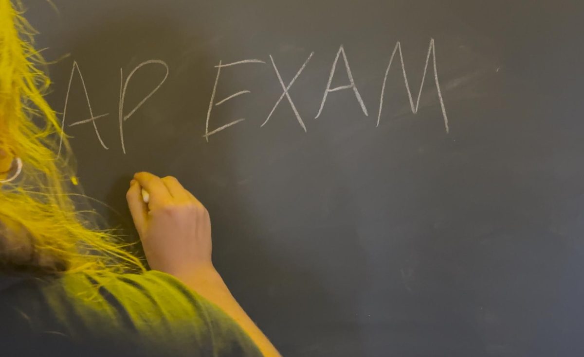 Teacher writing on the board about an AP Exam