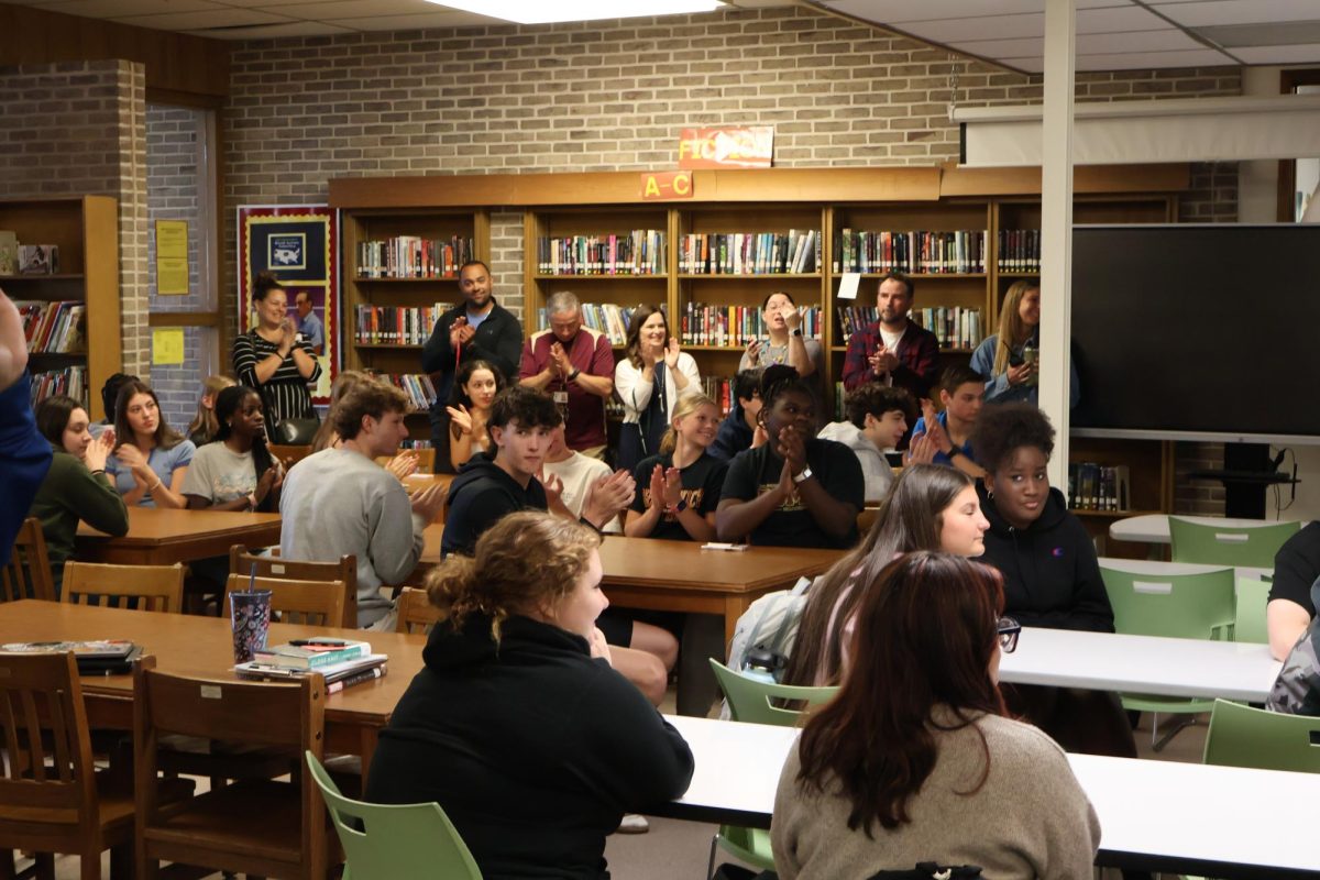 Classmates gather together to watch Ms. Kowalski's award ceremony.