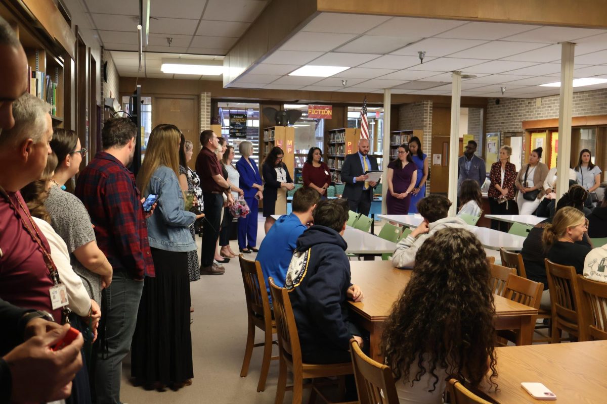 Various administrators are gathered around for the award ceremony.