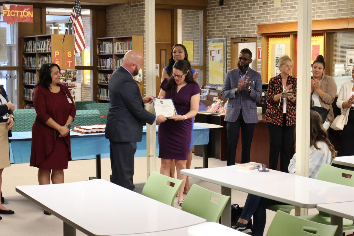 Mr. Schwarzernegger giving Ms. Kowalski an award.