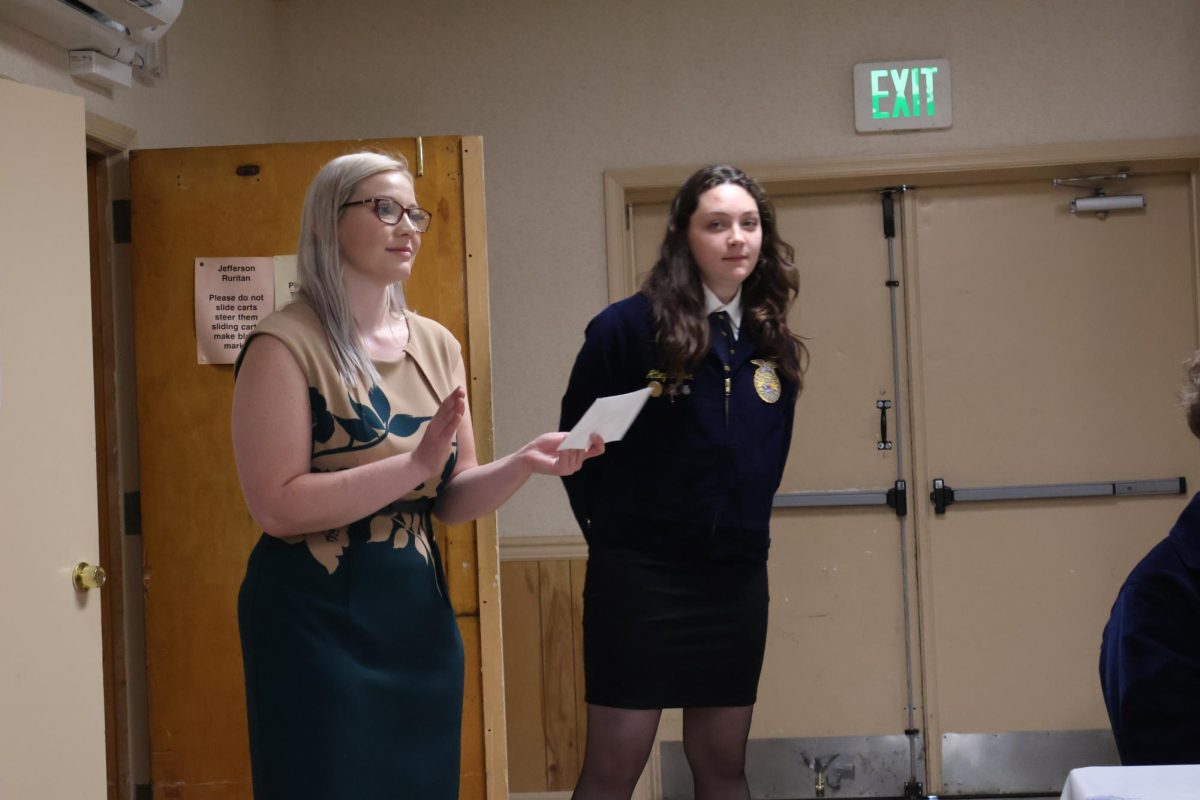 Mrs. Stockman giving a speech with Atley Shafer in the background. 