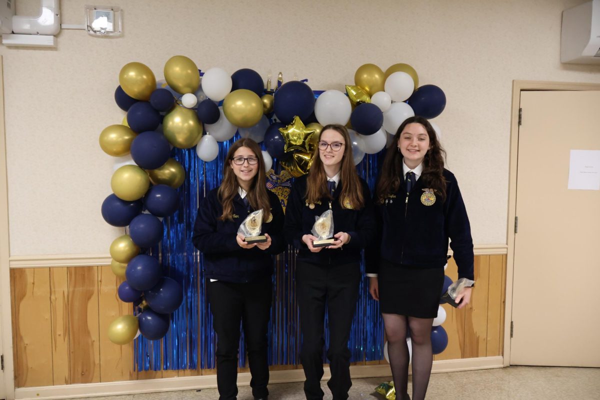 Savanah Sier, Caitlin Kelly, and Atley Shafer posing with awards. 