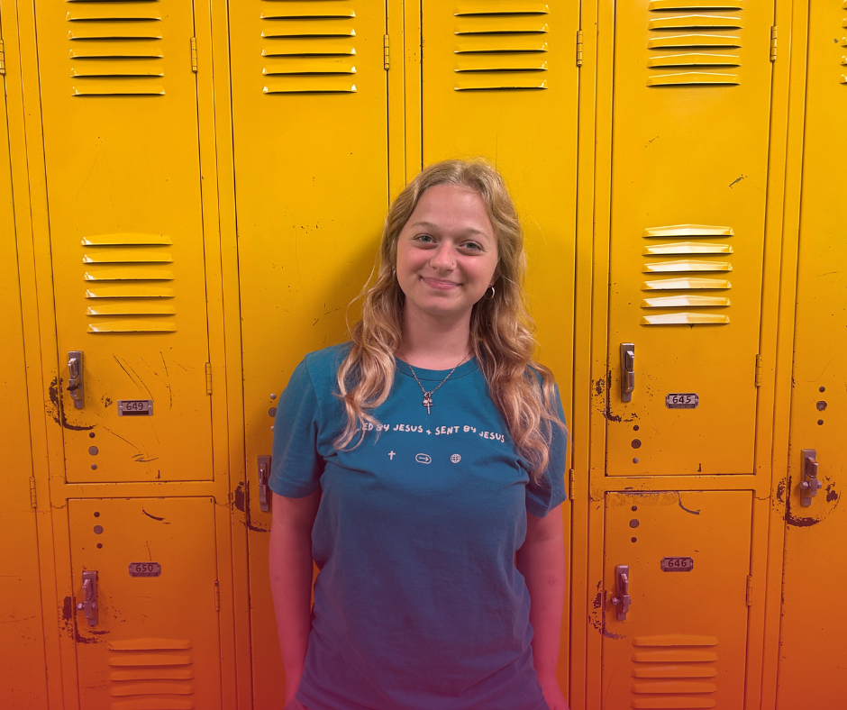 Carlee Poole in front of the yellow lockers in the upstairs hallway.