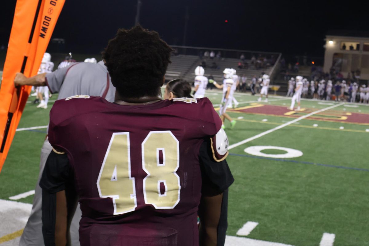Senior, Dorran Chales looks out at the field during a play near the 50-yard line.