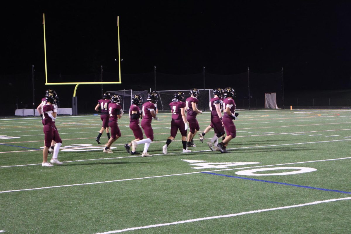 The football team runs out to make a play on the 35-yard line.