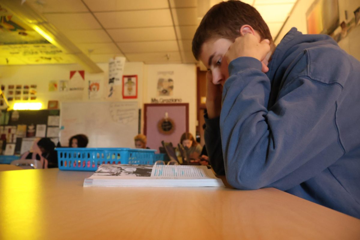 Sophomore Richard (Rickey) Riley, reads and flips through his English textbook in Mrs. Graziano's English 10 class.