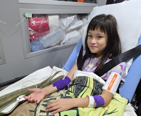 Millie Holdridge in an ambulance after a medical issue related to her birth complications.
