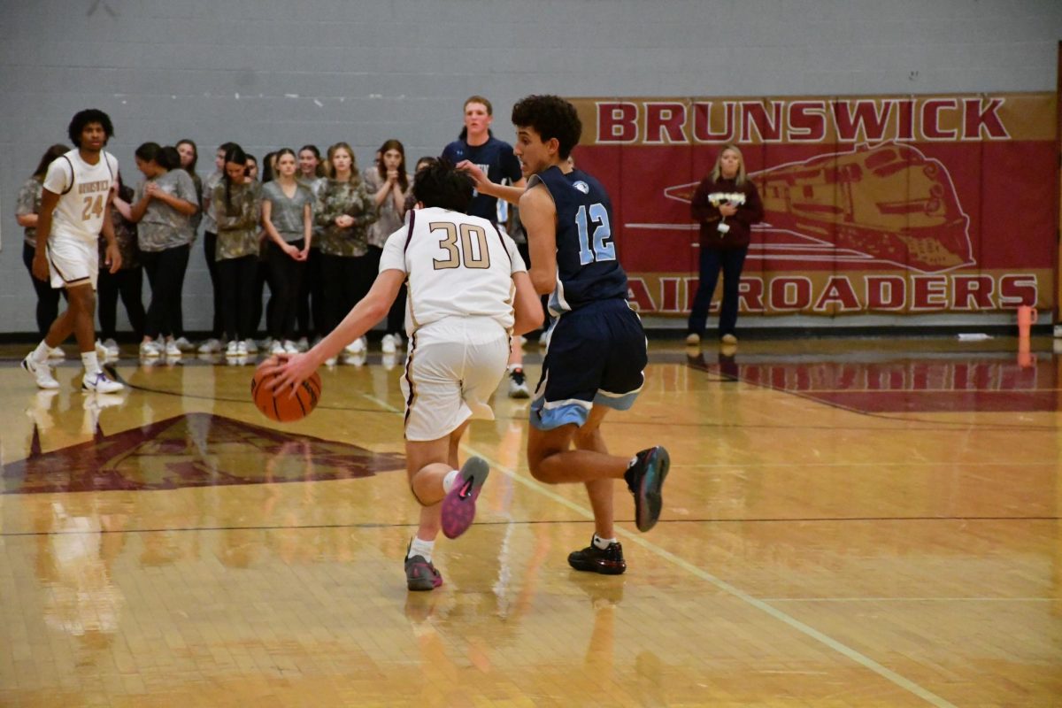Aaron Birney, '26, dribbles up court towards Andrew Jones, '26.

Photo taken by Lindsey Pearre