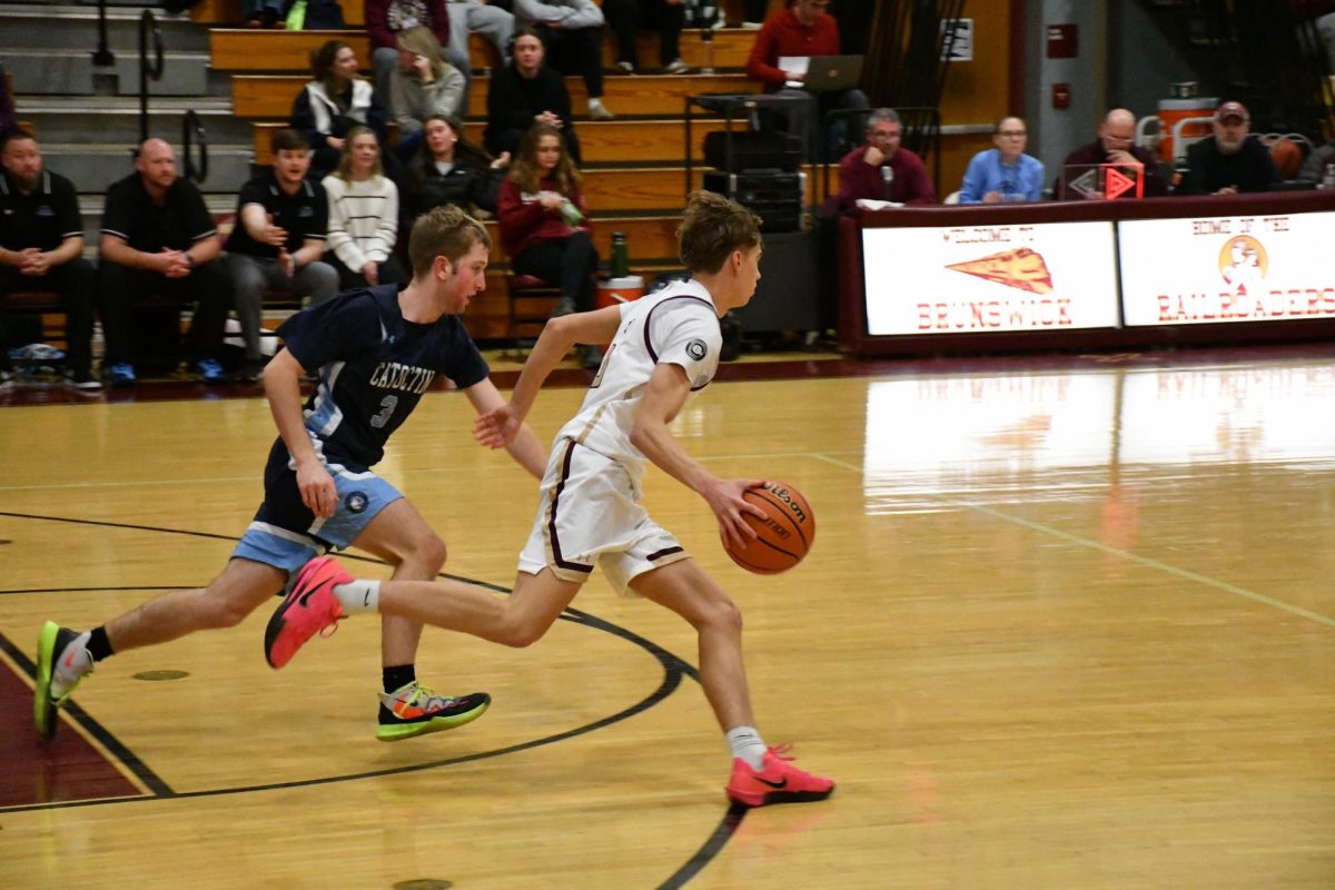 Nick Martinis, '27, dribbling down court during the varsity basketball game.

Photo taken by Lindsey Pearre