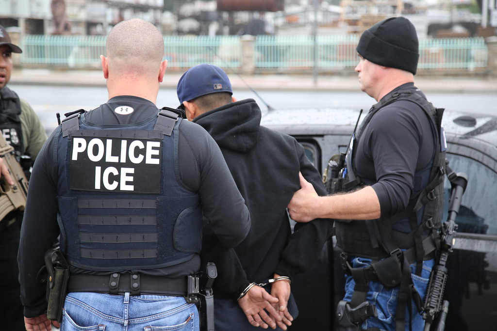 Immigration and Customs Enforcement officers are detaining an individual in Public. ERO Cross Check 2017 by Ron Rogers is licensed under CC PDM 1.0.