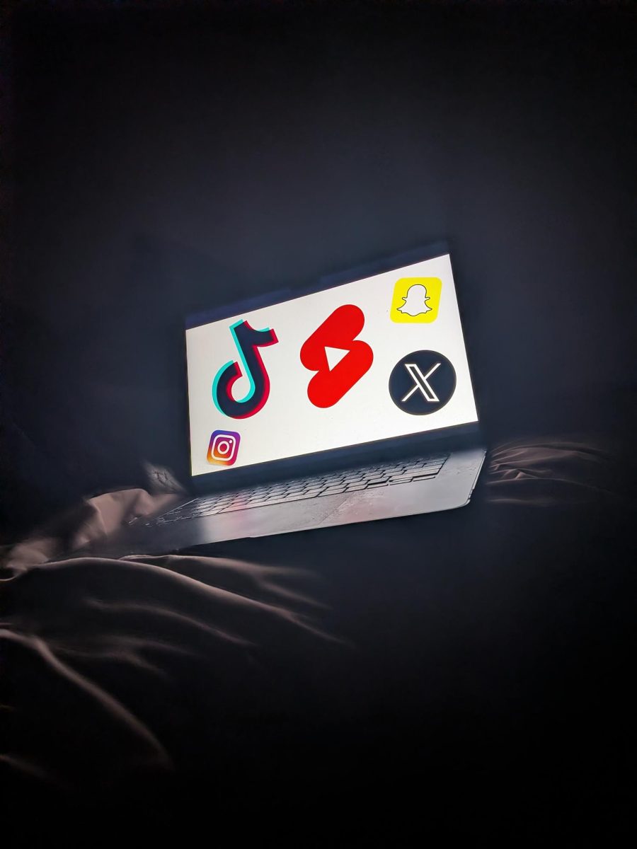 Laptop on bed with the logos of different media companies that specialize in short form videos.