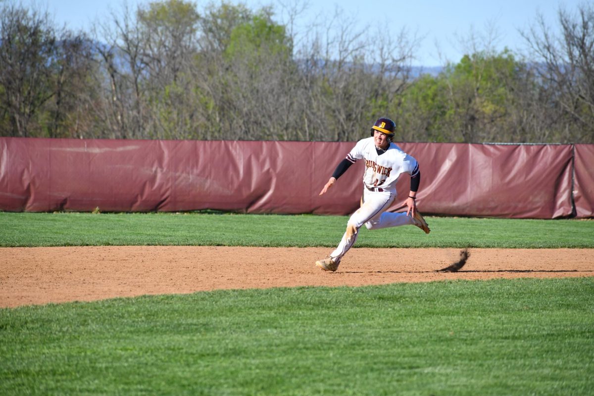Shortstop, Carter Vinar, junior, rounds second base and heads to third. 