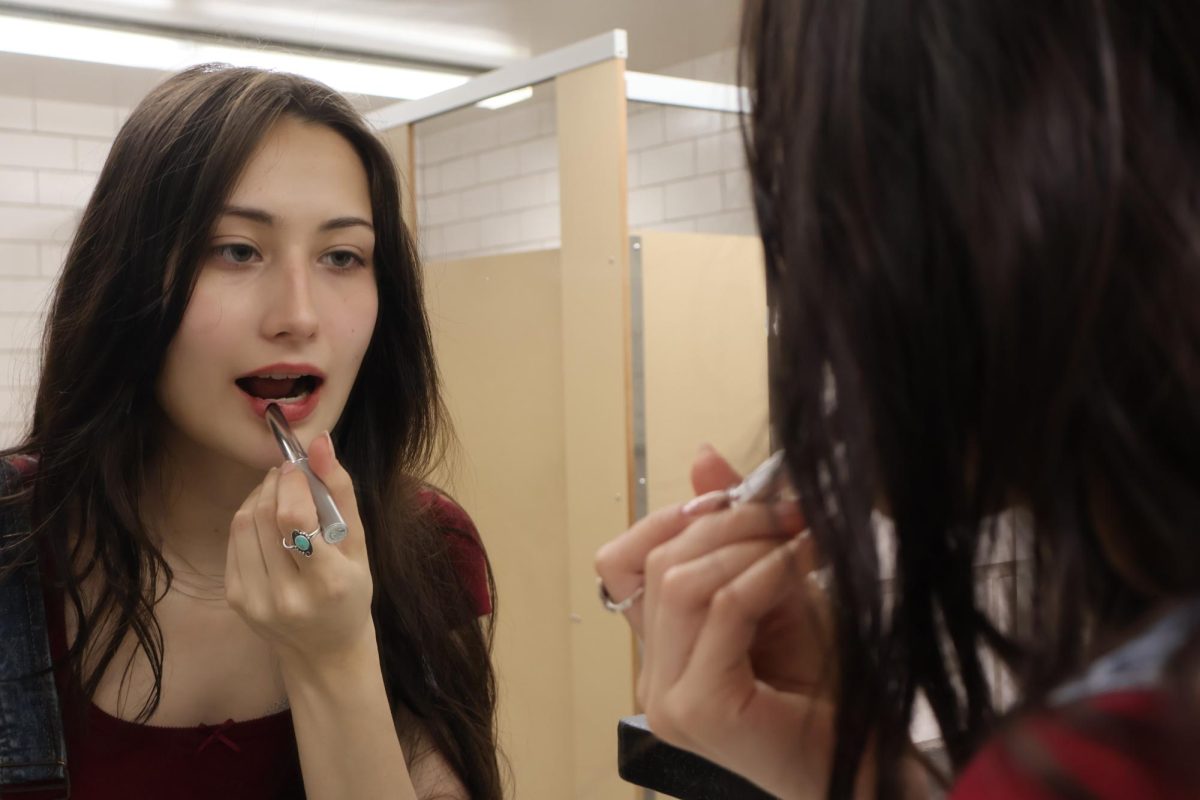 Brunswick High School student applying liptick in the bathroom. 