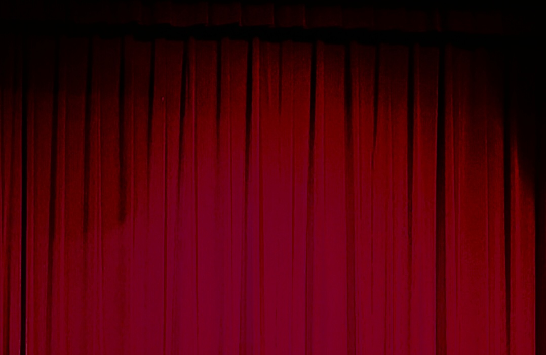 The red stage curtains shining brightly in the Brunswick High School auditorium.
