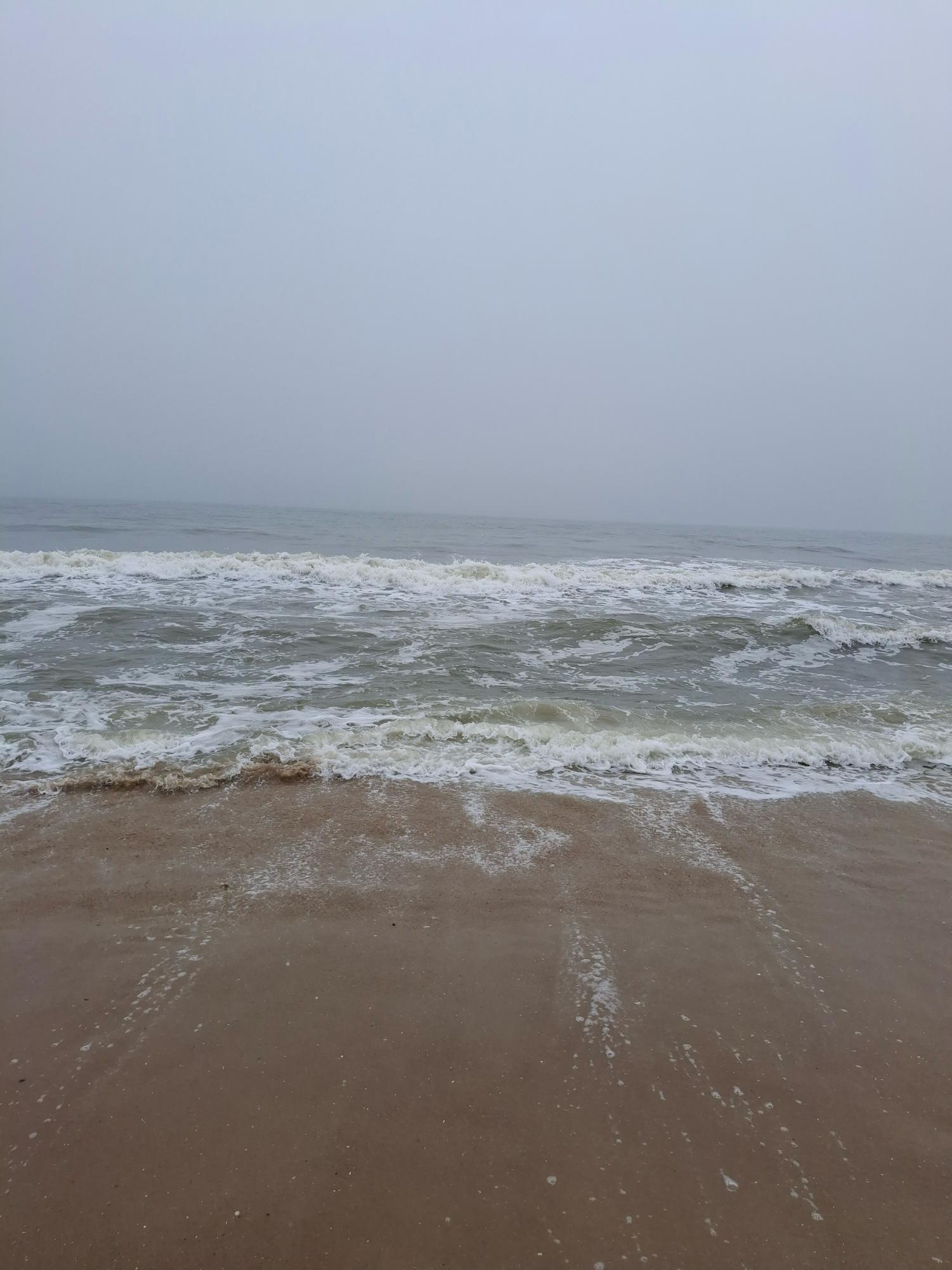 Waves crashing onto the sand at the beach in Ocean City, Maryland, a common vacation spot.